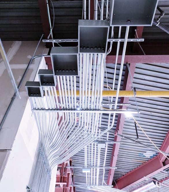 Neatly run electrical conduit and wiring across a commercial ceiling